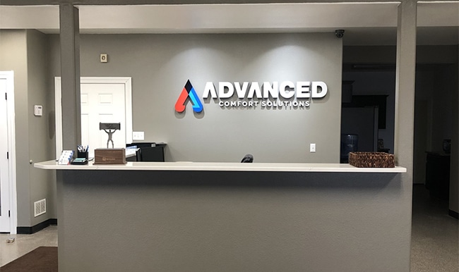 The front office of Advanced Comfort Solutions with a desk and sign behind it