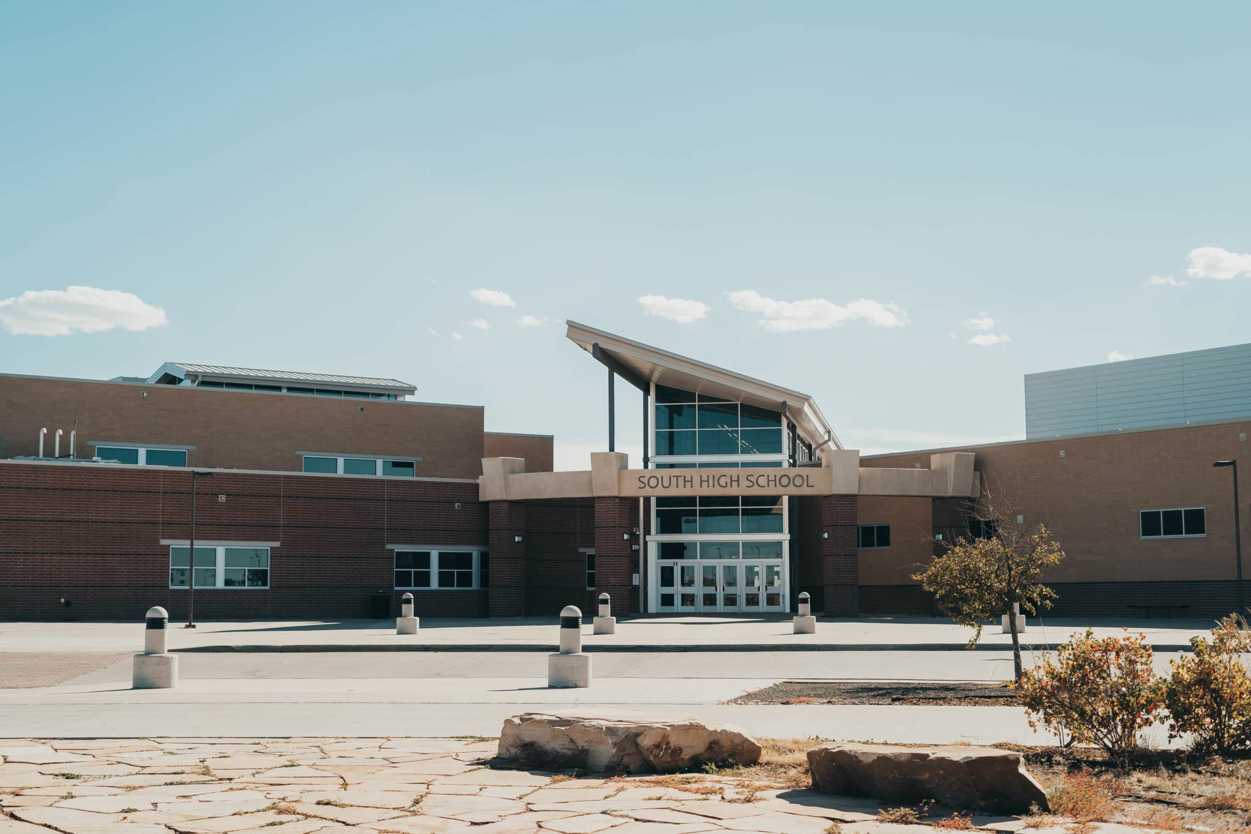 A large school with windows in the front above the main entrance doors and brick walls along the sides