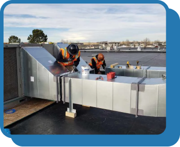 two men working on ductwork on a roof