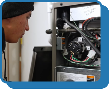 Someone looks at the interior of a furnace unit with cables and cords exposed